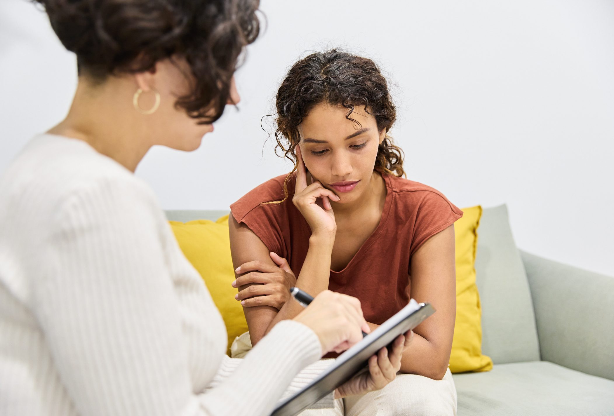 Counseling session with two women discussing notes.