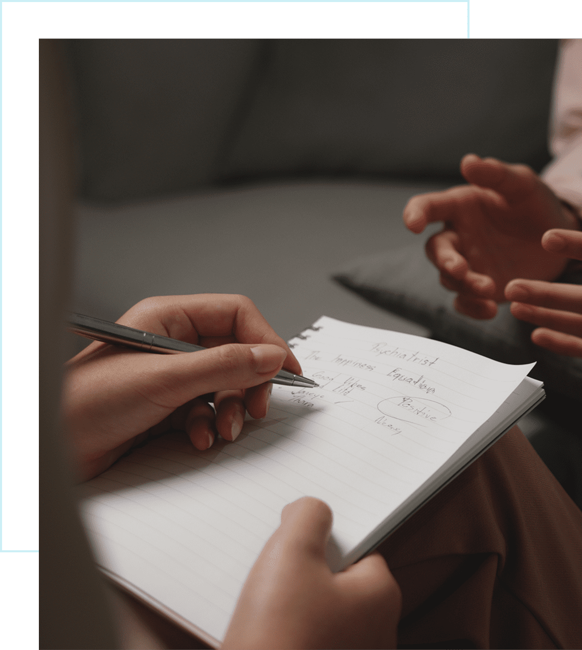 Person writing notes during a discussion.
