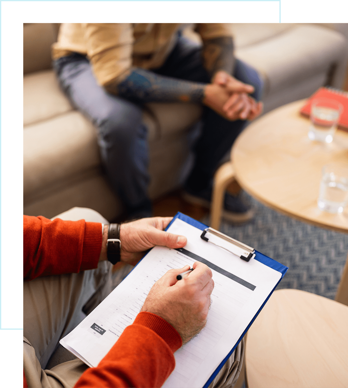 Therapist taking notes during a counseling session.