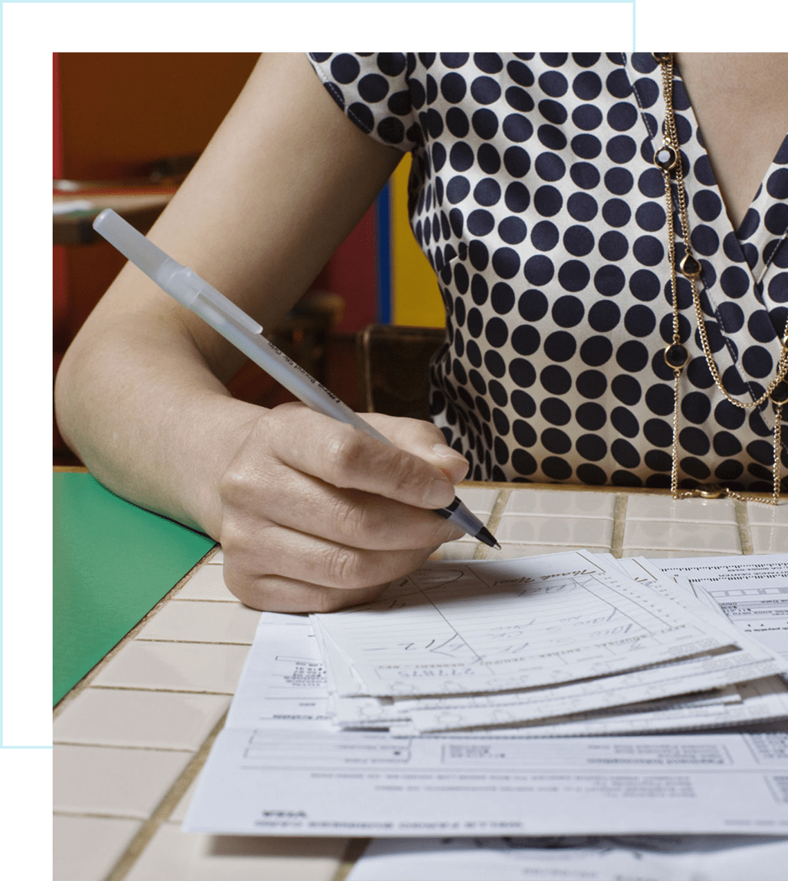 Person writing on papers at a table.